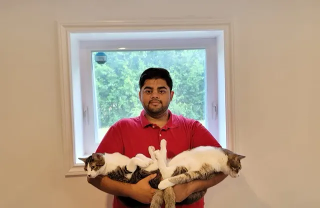 Abbas holding his two cats, Mimi and Bubba