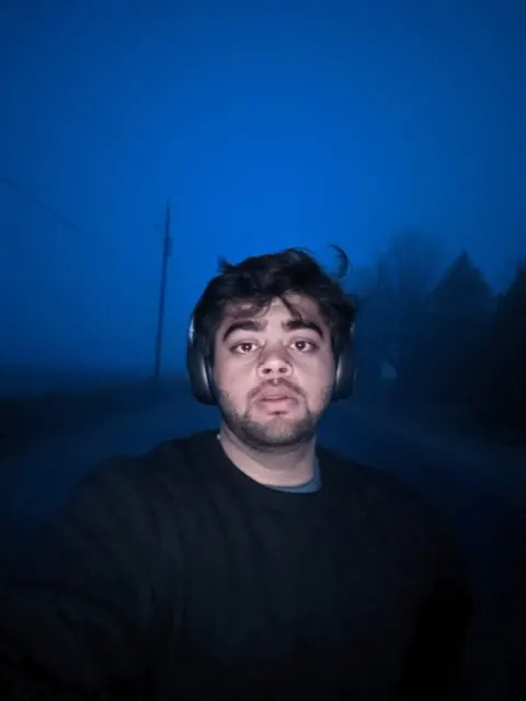 Abbas in headphones at dusk